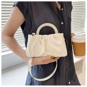Détail du sac nuage plissé crème avec poignée en perles et texture cuir PU doux