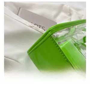 Detailed macro view of precision stitching on a neon green transparent jelly tote bag