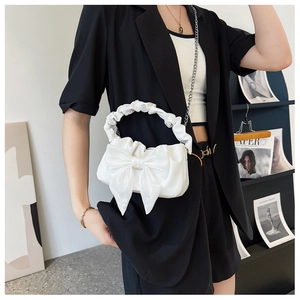 Detail of white bow bag with ruffled cloud handle and detachable silver chain