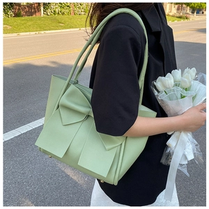 Détail du sac cabas vert sauge avec grand nœud décoratif et texture en cuir