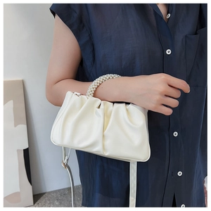 Sac nuage froncé beige chic avec poignée en perles et bandoulière sur modèle