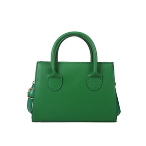 Minimalist green trapezoid handbag with gold hardware and adjustable strap on white background