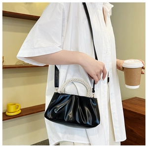 Détail d'un sac nuage noir plissé avec poignée en perles et bandoulière amovible