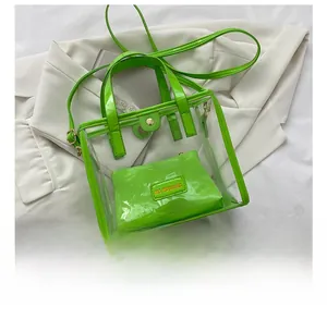 Detailed top view of transparent PVC tote bag and green inner pouch showing size scale