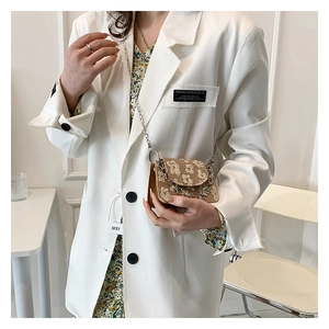 Mini floral chain bag with silver strap styled over a white blazer for a chic look