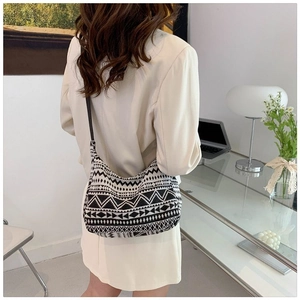 Gros plan d'une femme portant un sac croissant en maille géométrique noir et blanc chic
