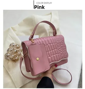 Pink crossbody bag detail with crocodile texture and mini wave-edged coin purse