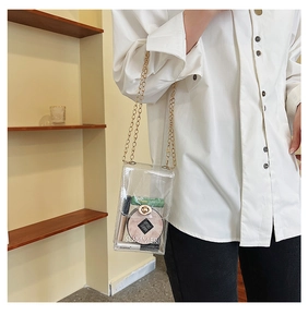 Detailed view of clear PVC mini crossbody bag with gold chain strap and turn-lock closure