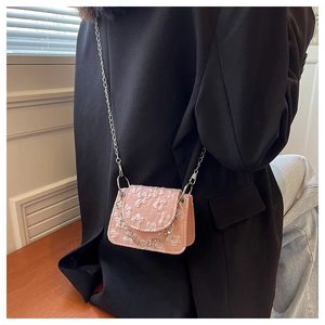 Detail of pink floral jacquard mini crossbody bag with silver chain worn by a model