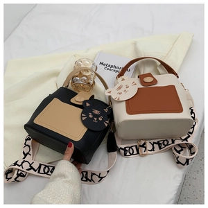 Detail of color-block bucket bags with wooden buckles and stylish wide shoulder straps