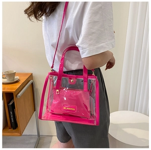 Detail of rose red transparent PVC tote bag with matching inner pouch and gold hardware