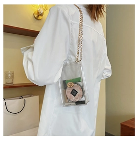 Detail view of transparent PVC crossbody bag with gold chain strap and Summer lettering