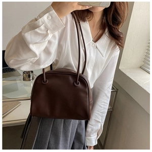 Deep brown minimalist faux leather shoulder bag styled with a white shirt and grey skirt