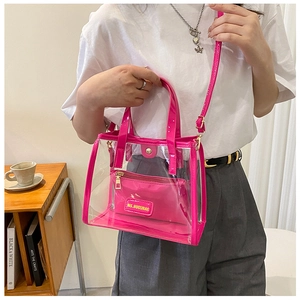 Macro detail of rose red transparent PVC tote bag featuring removable inner pouch