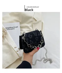 Detail of black jacquard round bag with clover chain strap and silver metal handle
