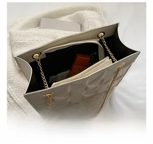 Détail de l'intérieur du grand sac matelassé avec chaîne dorée et compartiments multiples