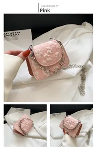 Close-up of pink mini crossbody bag with 3D floral embroidery and silver flower chain