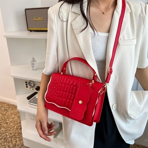 Red crocodile pattern crossbody bag with white wavy trim and small matching pouch