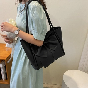 Sac fourre-tout noir avec grand nœud et finition en cuir mat porté épaule