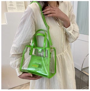 Detail of neon green trim, gold hardware and matching inner pouch on transparent tote bag