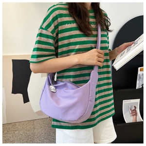 Détail du sac bandoulière croissant lilas avec un charm mignon et une large sangle