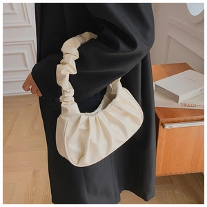 Detailopname van een crème geplooide cloud bag van zacht kunstleer met een halve maan structuur