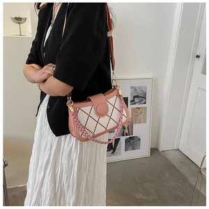 Quilted crossbody bag with pink woven handle and adjustable strap shown on model