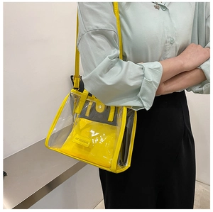 Detail of yellow transparent PVC tote bag with inner pouch and embossed logo text