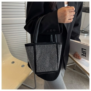 Detail of a black bucket bag with sparkling silver rhinestones and sturdy double handles