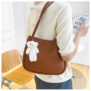 Sac fourre-tout en cuir marron avec breloque ours blanc dans un intérieur cosy