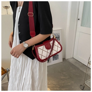Close-up of a red and white quilted bag with dual straps and contrast stitching details