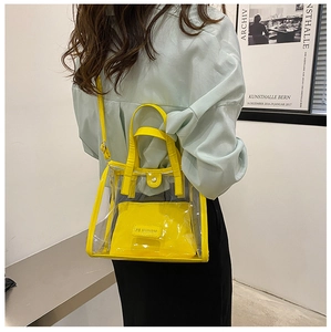 Rear view of model carrying a bright yellow transparent PVC tote with leather pouch