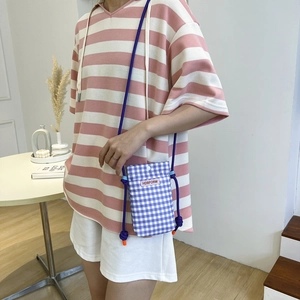 Mini-Handytasche mit lila-weißem Karomuster, orangefarbenem Etikett und Seil-Schultergurt