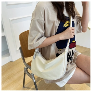 Détail du sac hobo en toile avec charm pixel-art et fermeture éclair argentée