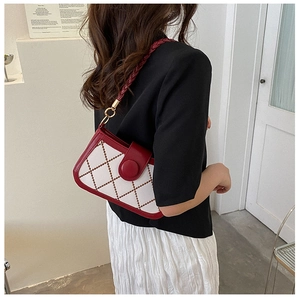 Detail showing the retro quilted pattern and braided strap on the red and white crossbody bag