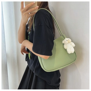 Vue détaillée du sac hobo vert clair avec pendentif ours en peluche blanc sur la sangle