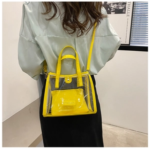 Bright yellow transparent PVC tote with inner pouch shown on shoulder for capacity
