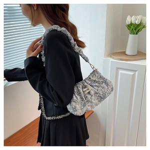 Détail du sac nuage gris marbré avec chaîne florale en métal et bandoulière plissée