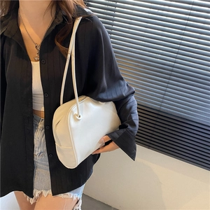 Minimalist white leather shoulder bag for women shown on model in natural light