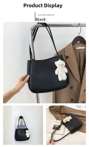Détail du sac cabas en cuir grainé noir avec un joli pendentif ours en peluche blanc