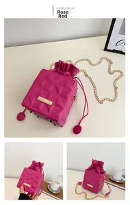 Detail of rose red quilted leather handbag with gold chain strap and drawstring closure