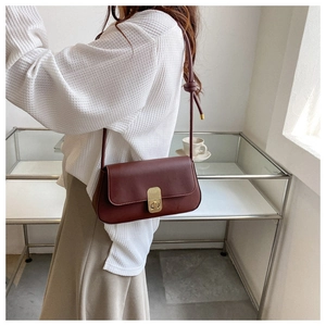 Retro burgundy leather crossbody bag with vintage metal lock shown on a model