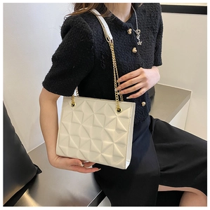 Détail du sac à bandoulière matelassé géométrique crème avec chaîne dorée sur noir
