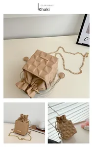 Detail of khaki bucket bag with quilted texture, gold chain, and secure drawstring closure