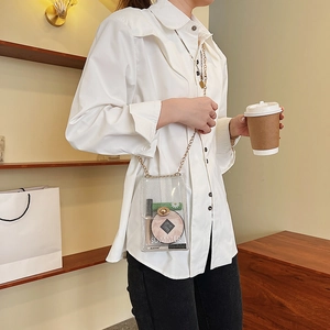 Chic transparent PVC jelly crossbody phone bag with gold chain strap shown in a cafe