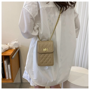 Close-up of beige quilted crossbody bag with gold chain strap and metal lock closure