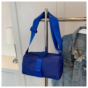 Detail of blue waterproof nylon barrel bag with wide adjustable shoulder strap