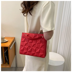 Détail du sac à main rouge à texture géométrique 3D avec chaîne dorée et poignée