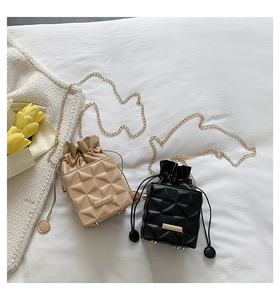 Detail of khaki and black quilted drawstring bucket bags with golden chain straps