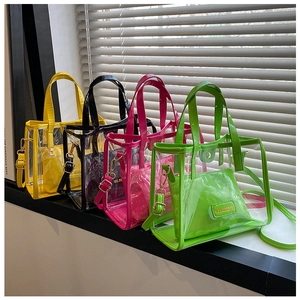 Four colorful transparent PVC tote bags with inner pouches shown on a sunny windowsill
